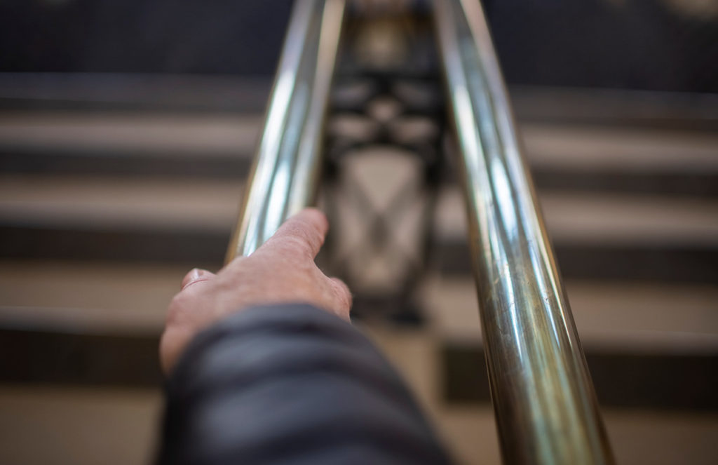 Hand on metal stair railing