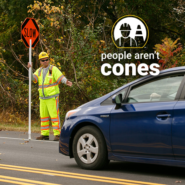 Flagger Force crew member dressed in high-visibility yellow directing a car.